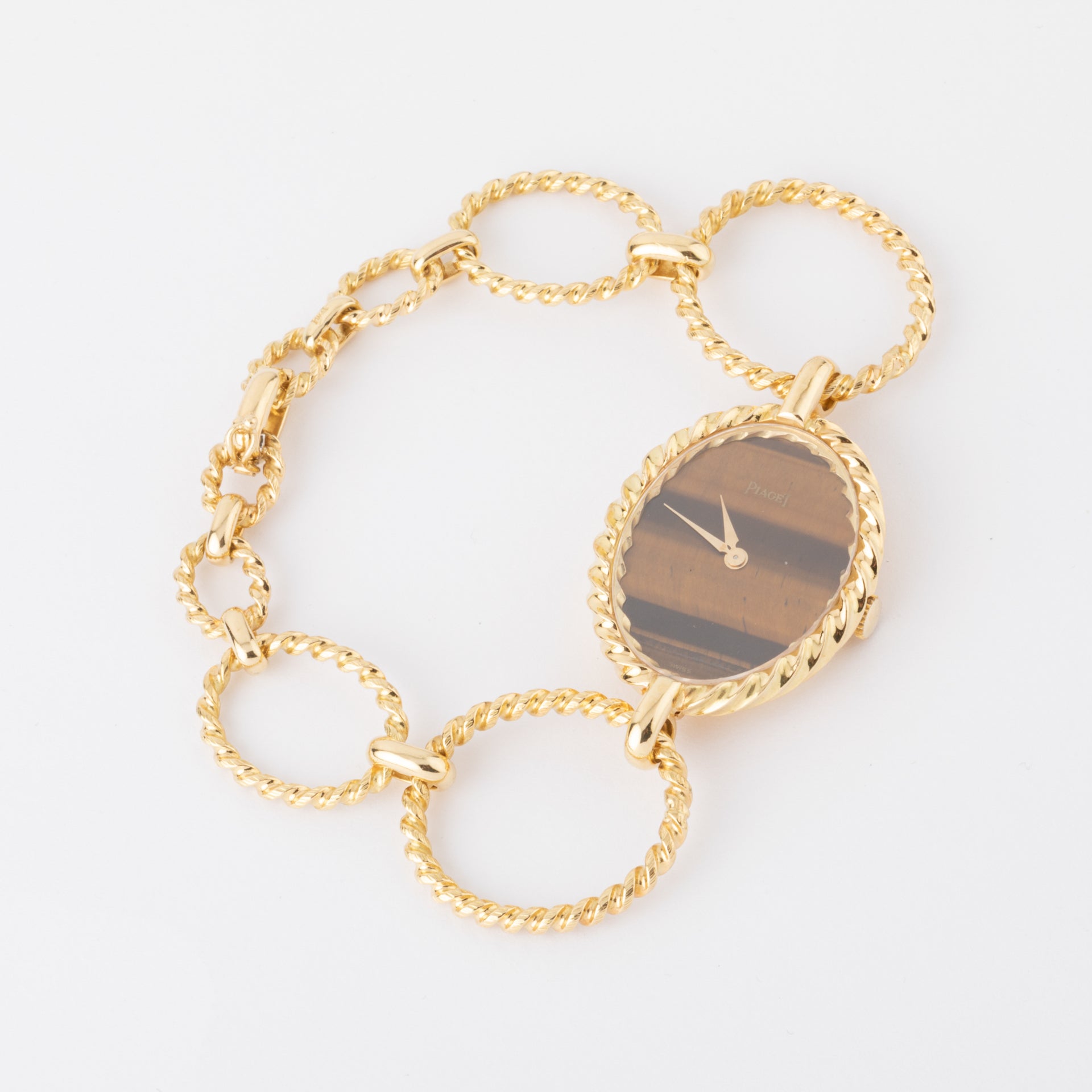 Vintage Piaget, a gold and tiger's eye watch on gold.