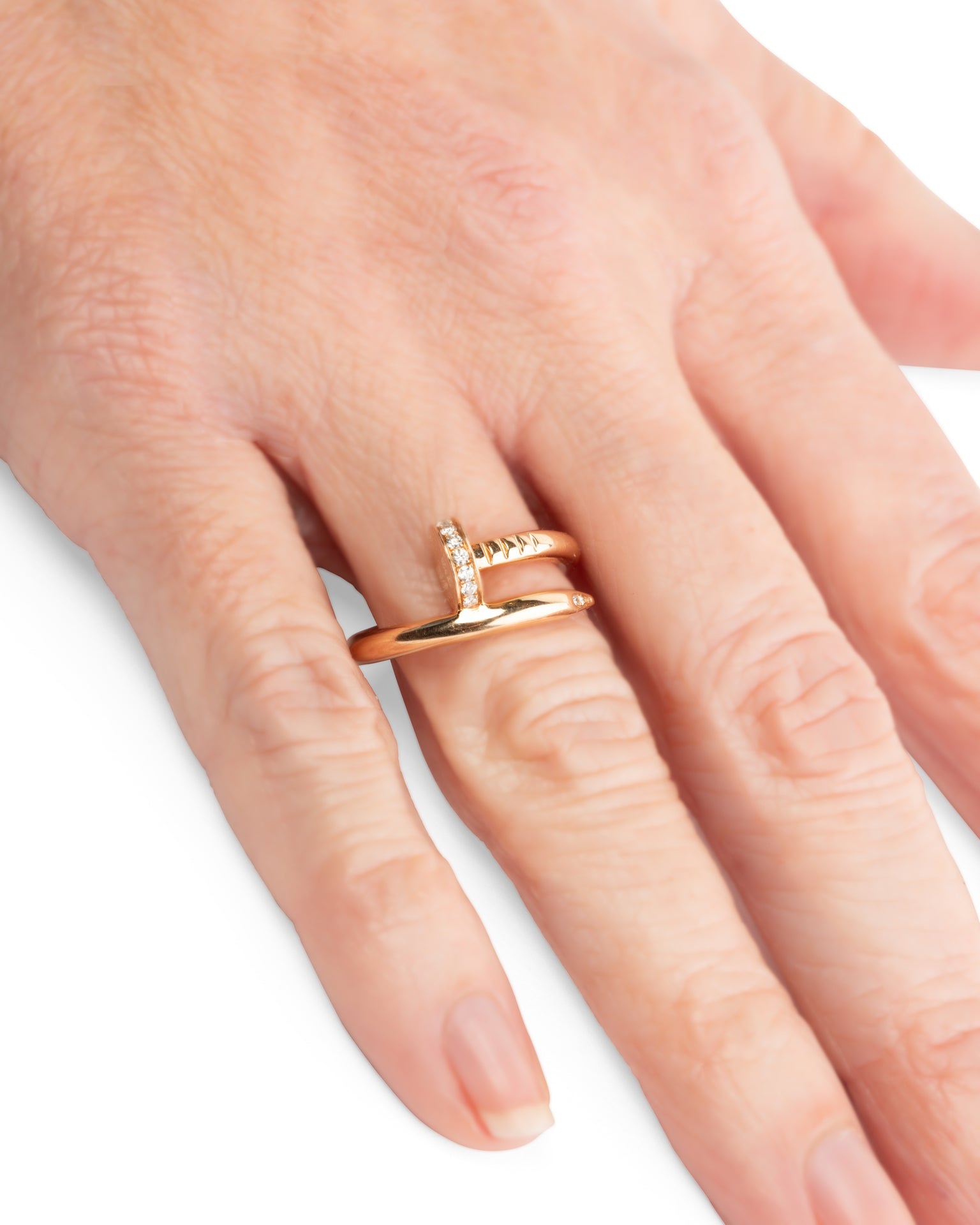 Bague Cartier "Juste un clou" occasion portée sur main, authentifiée en or rose et Diamants