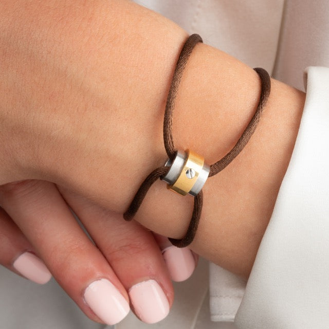Un bracelet Cartier or et acier sur cordon de cuir