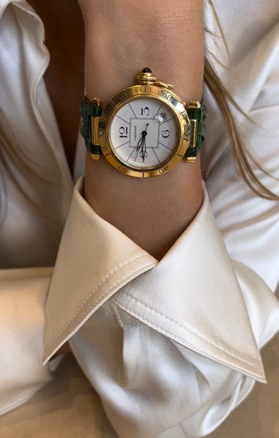 Une montre Cartier "Pasha" en or jaune sur bracelet cuir