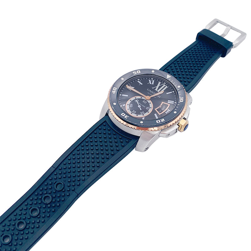 Cartier Calibre watch in gold and steel on a rubber strap.