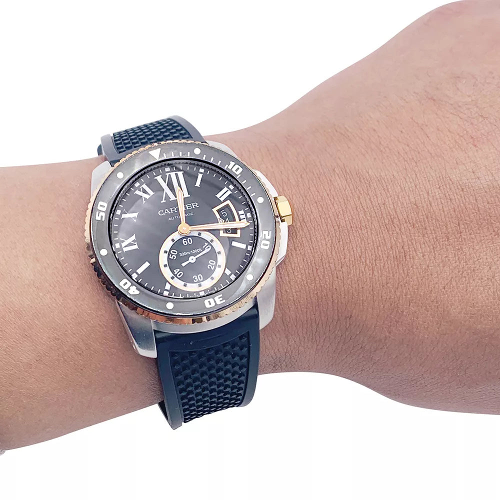 Cartier Calibre watch in gold and steel on a rubber strap.