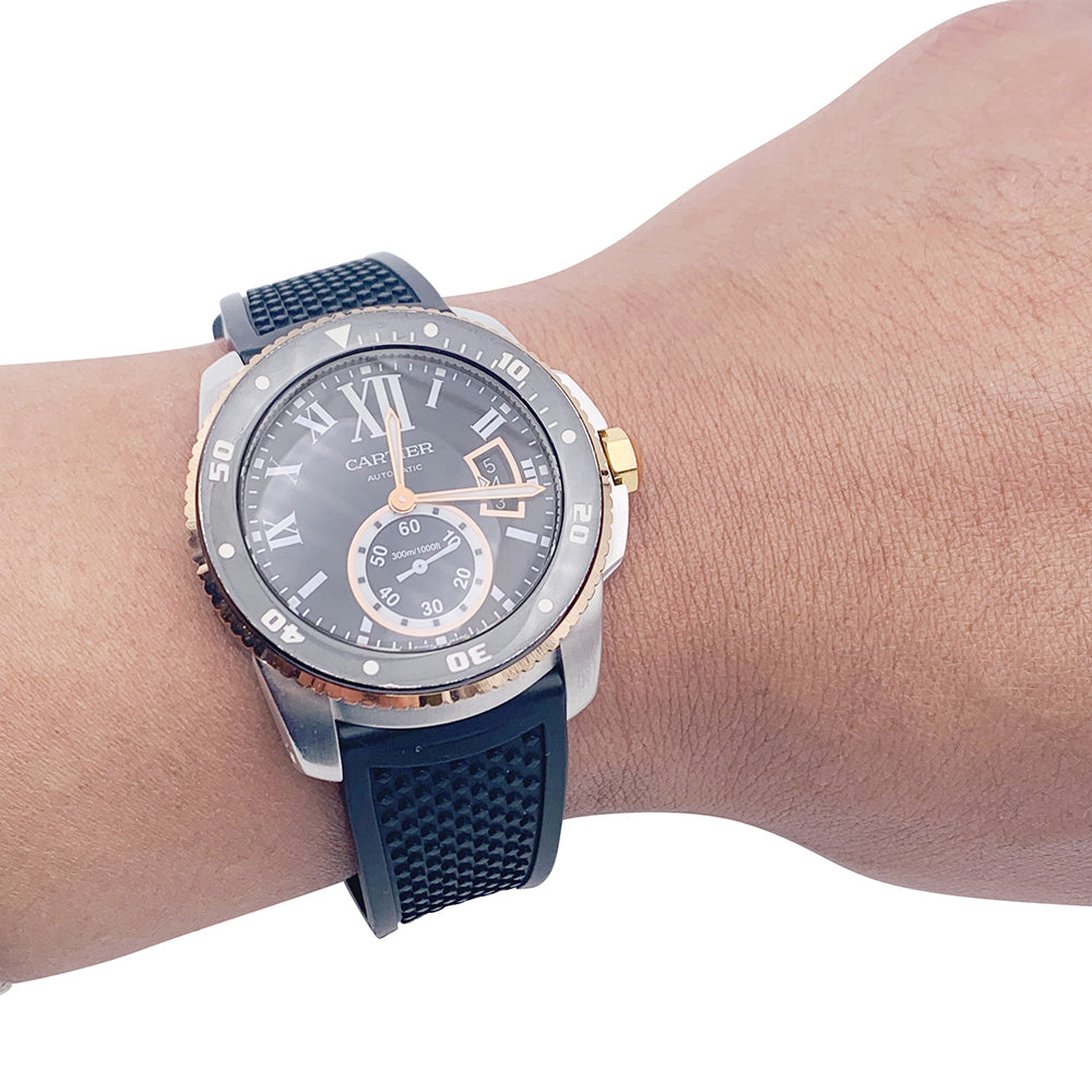 Cartier Calibre watch in gold and steel on a rubber strap.