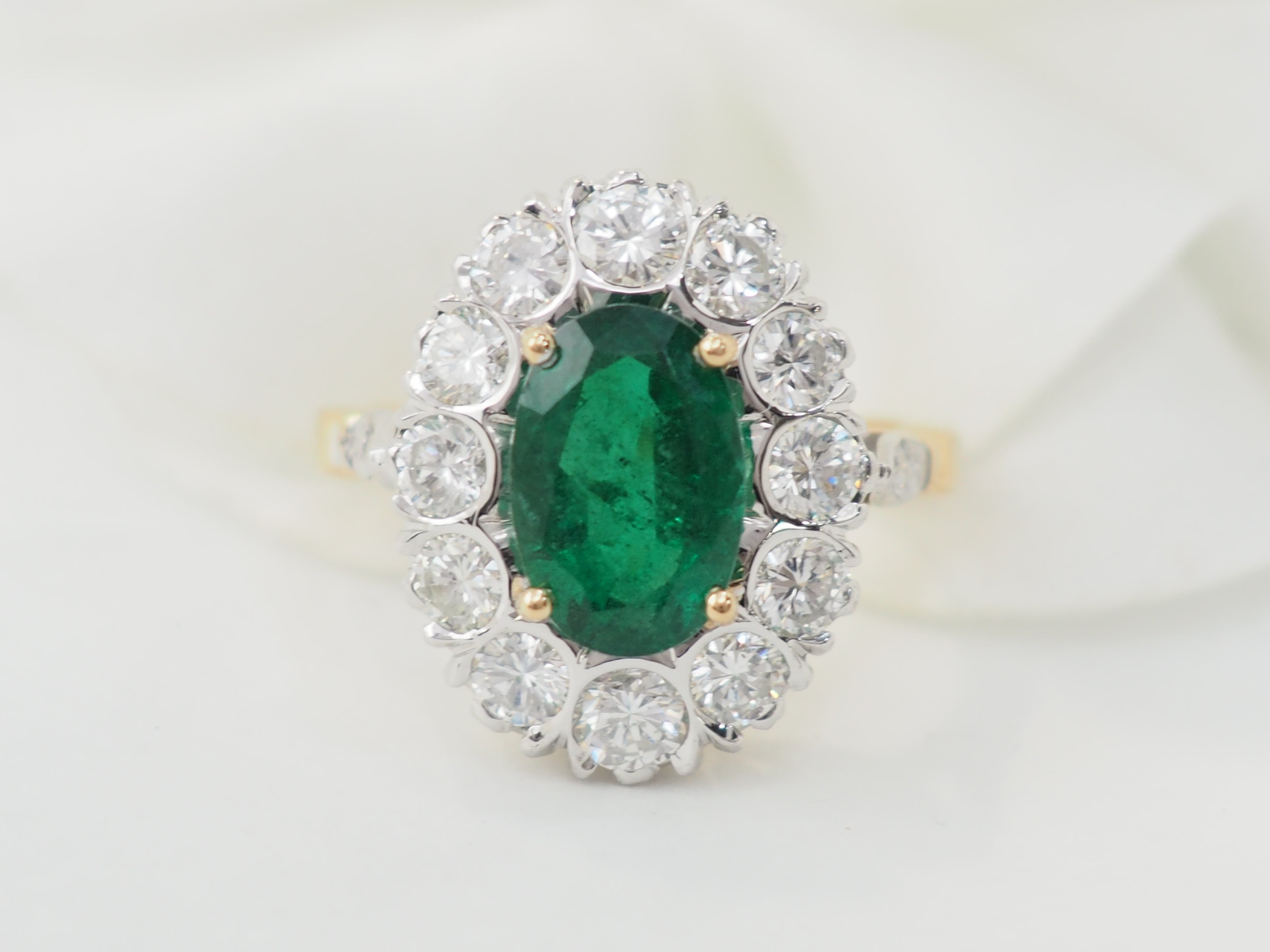 Bague entourage en or bicolore, émeraude et diamants