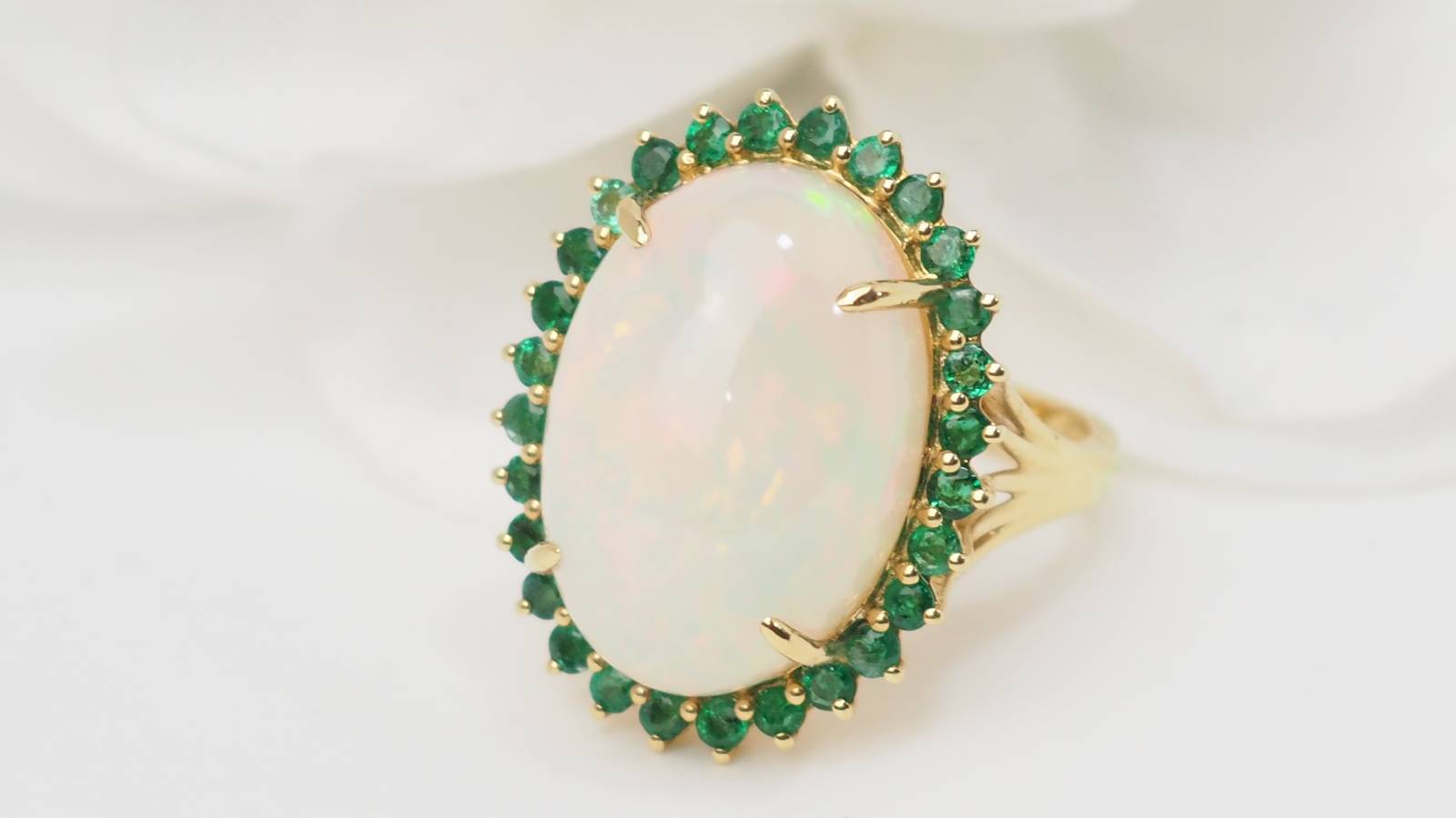 Bague ovale en or jaune, opale cabochon et émeraudes