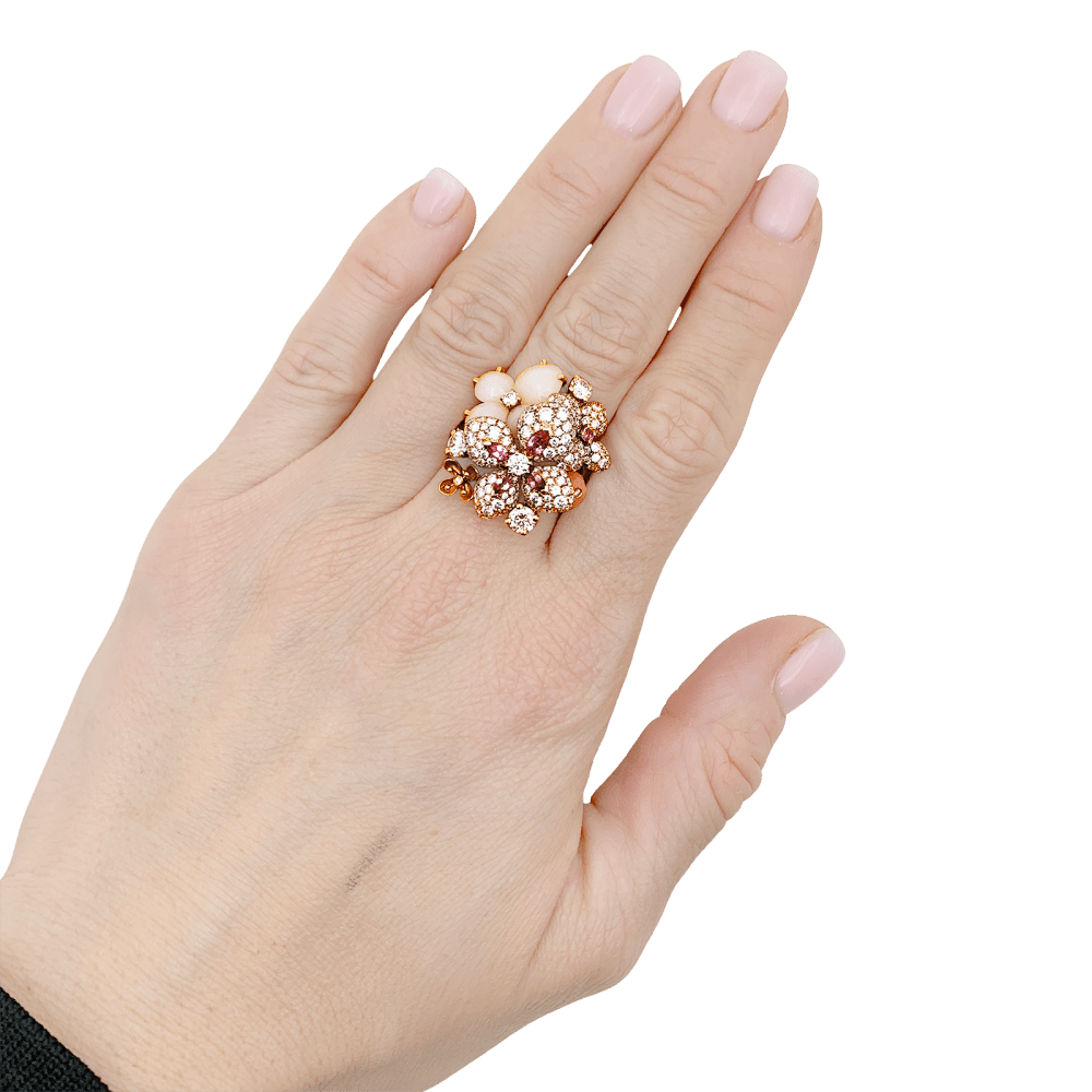 photo portée au doigt de la Bague Chaumet, « Hortensia Aube rosée », or rose, diamants, saphir rose et opales roses.