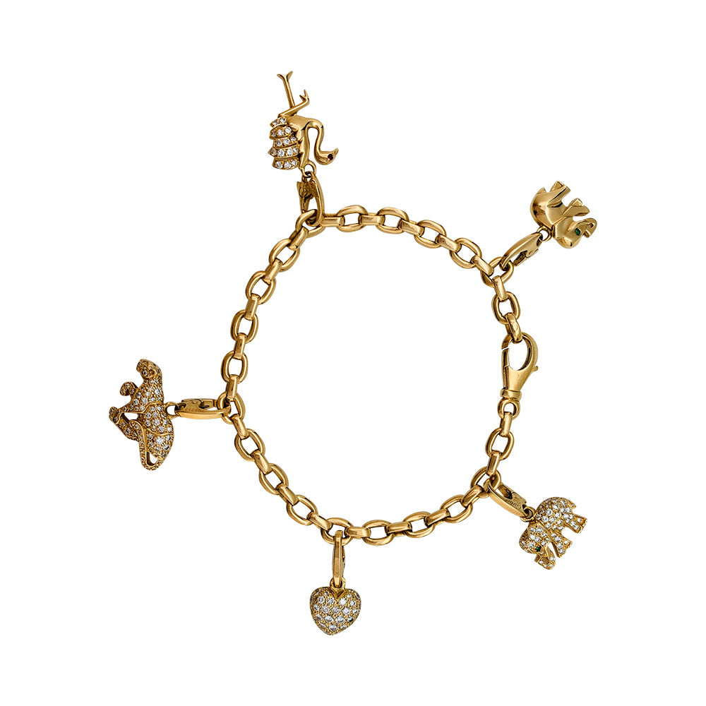 Bracelet Cartier en or jaune, 5 breloques,  diamants, émeraudes et rubis.