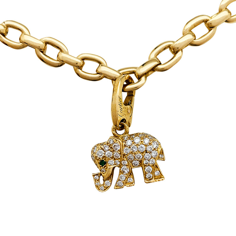 Bracelet Cartier en or jaune, 5 breloques,  diamants, émeraudes et rubis.