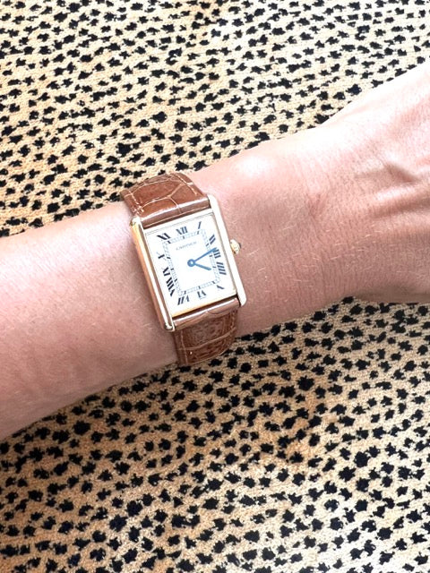 Une montre Cartier Tank femme en or jaune sur cuir