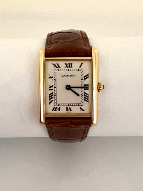 Une montre Cartier Tank femme en or jaune sur cuir