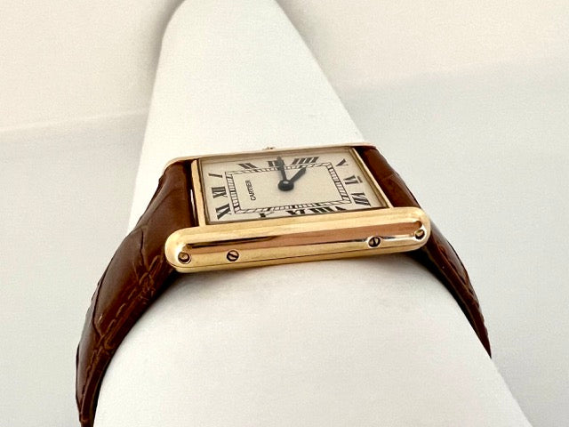 A Cartier Tank women's watch in yellow gold on leather