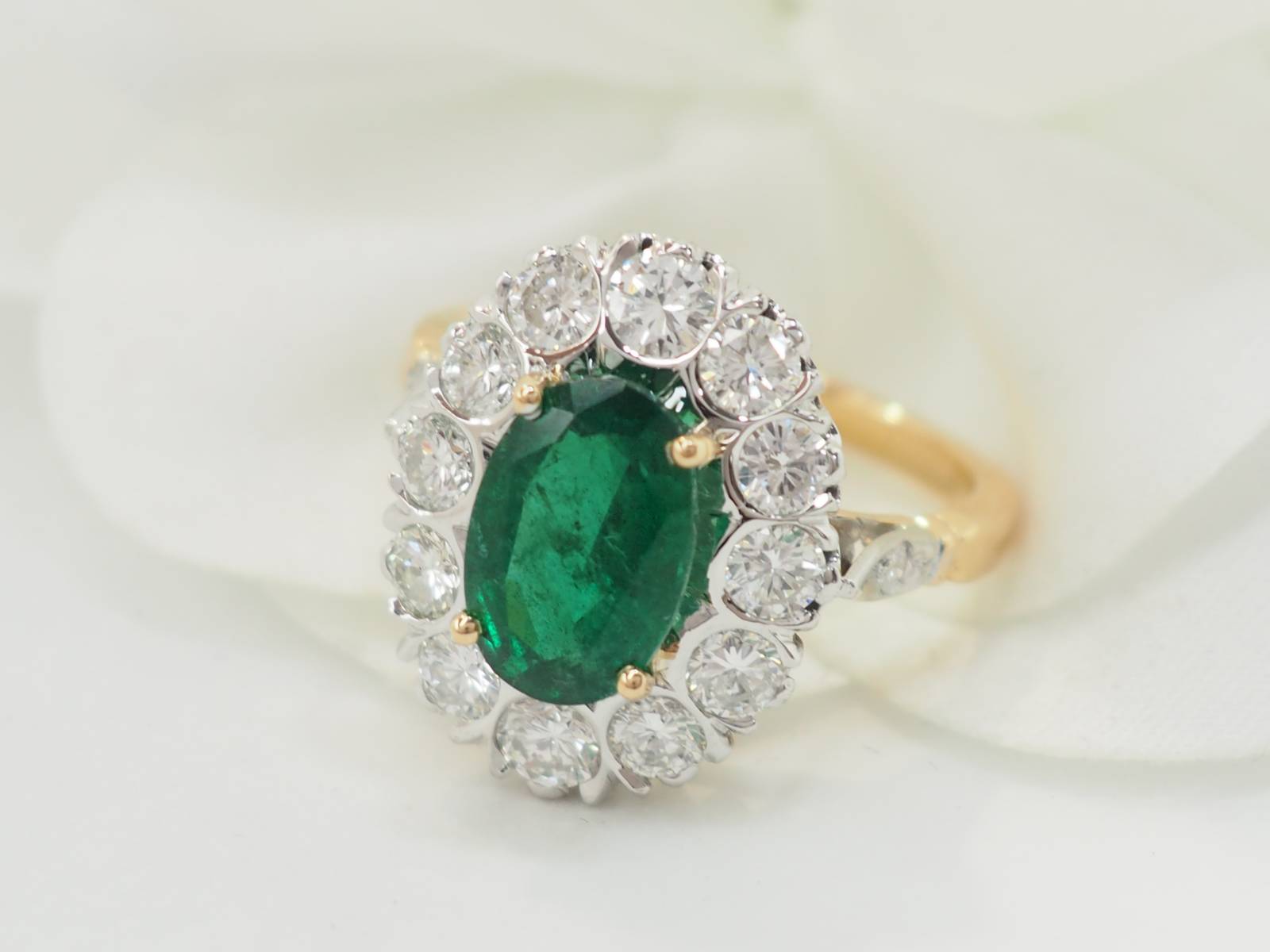 Bague entourage en or bicolore, émeraude et diamants