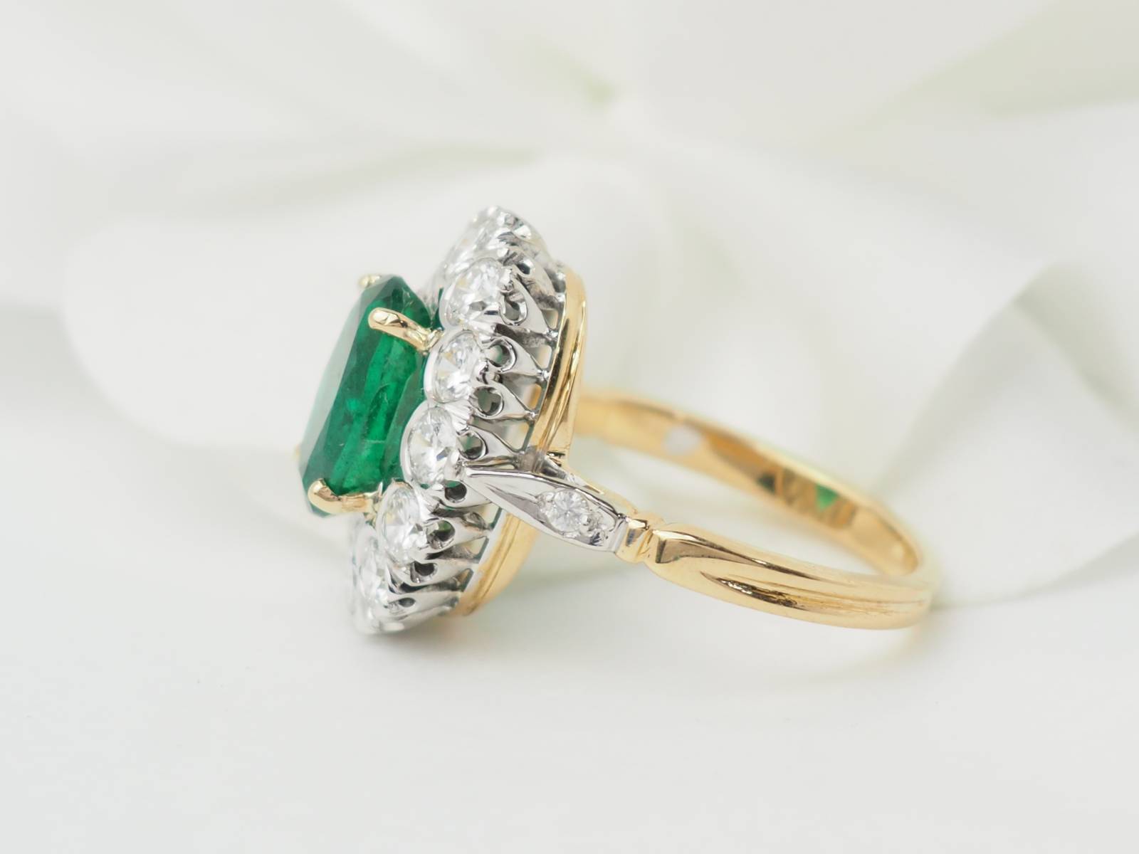 Bague entourage en or bicolore, émeraude et diamants