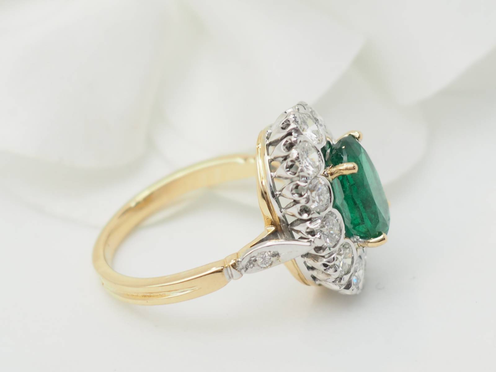 Bague entourage en or bicolore, émeraude et diamants