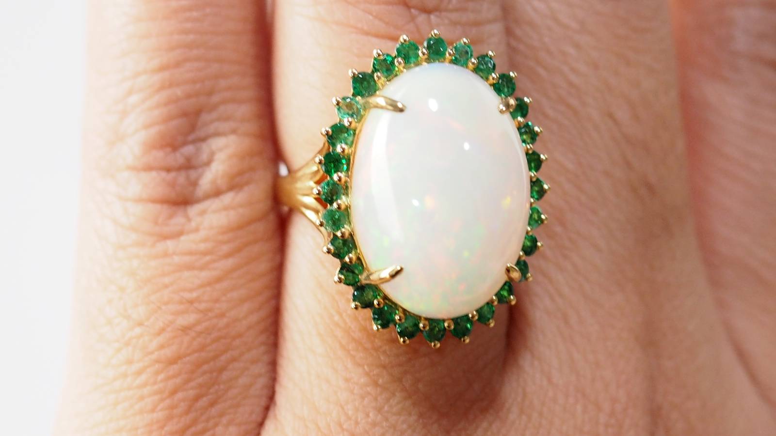 Bague ovale en or jaune, opale cabochon et émeraudes