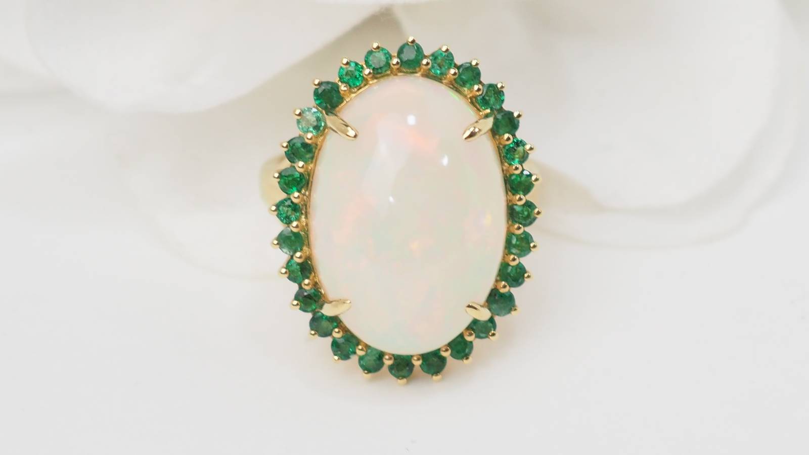 Bague ovale en or jaune, opale cabochon et émeraudes