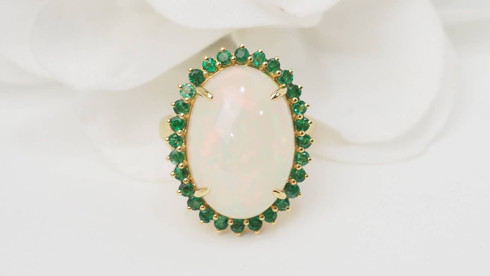 Bague ovale en or jaune, opale cabochon et émeraudes