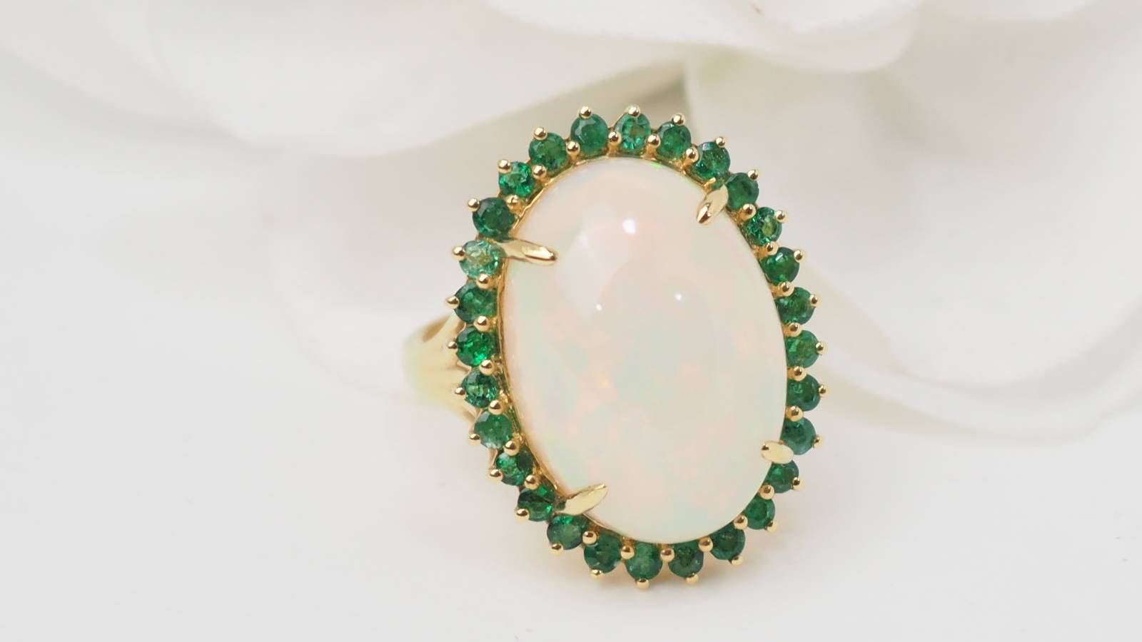 Bague ovale en or jaune, opale cabochon et émeraudes