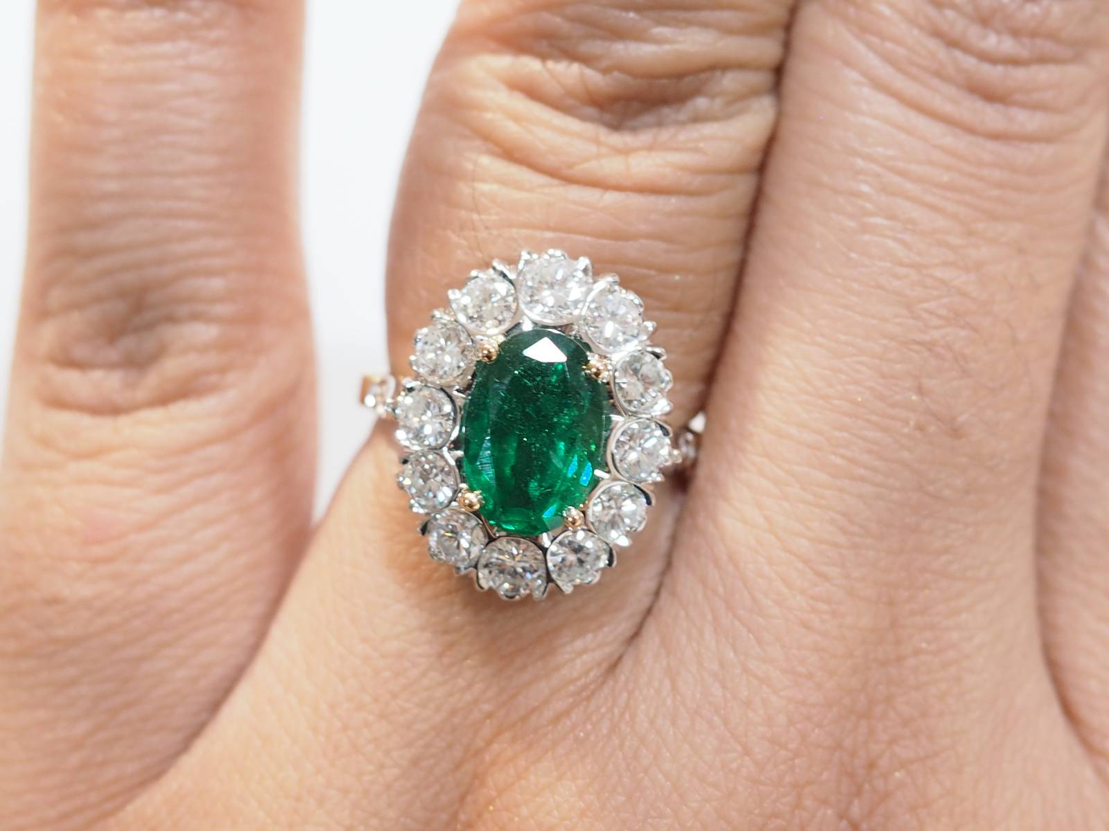 Bague entourage en or bicolore, émeraude et diamants