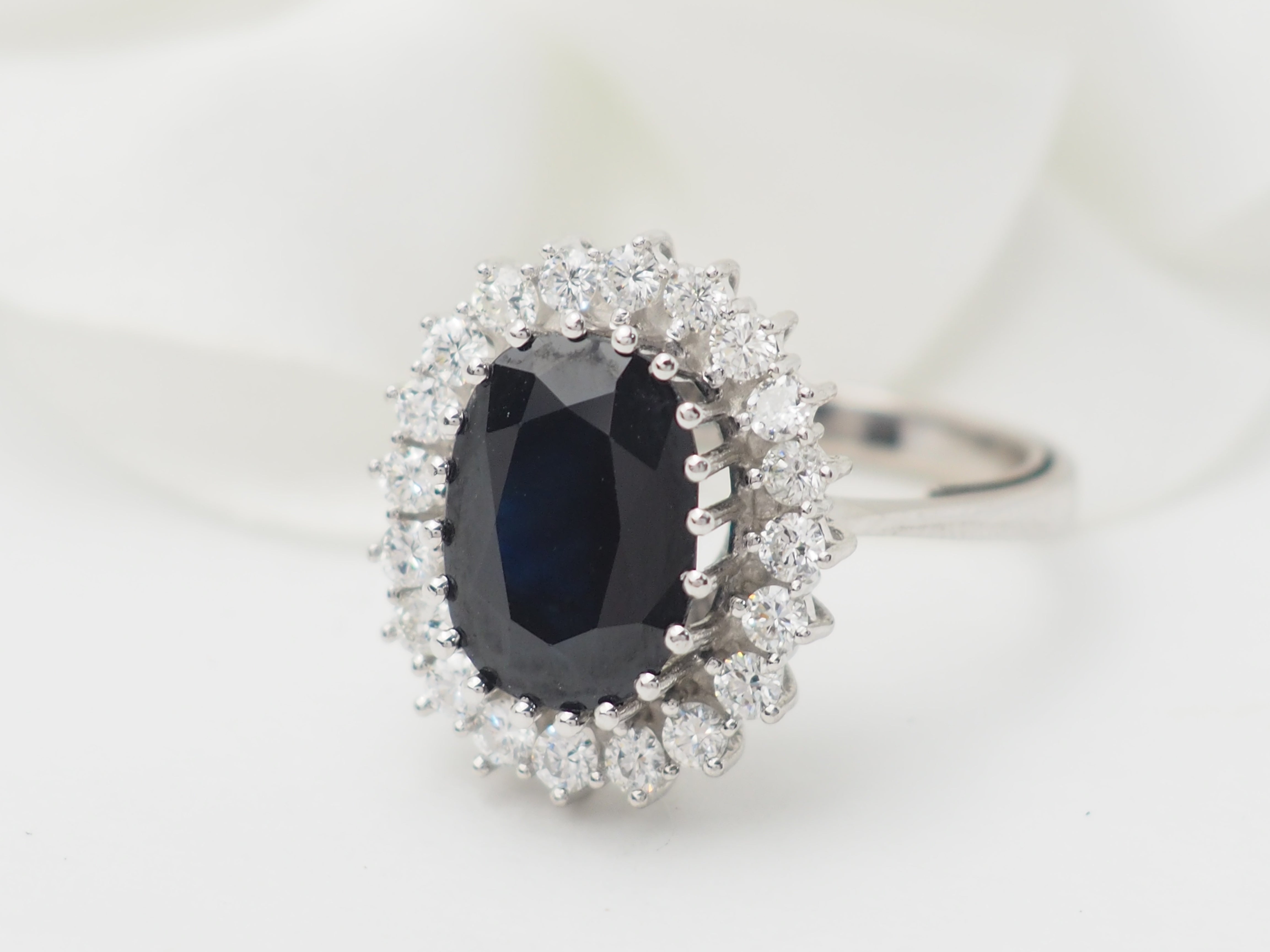 Bague entourage en or blanc, saphir ovale et diamants