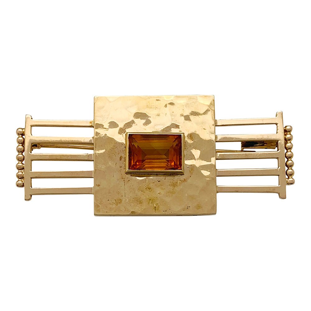 Une broche géométrique signée Jean Desprès en or jaune 750/000 martelé et lisse, centrée d’une citrine rectangulaire. Poids brut: 17,2 grammes. - Maison Eloe