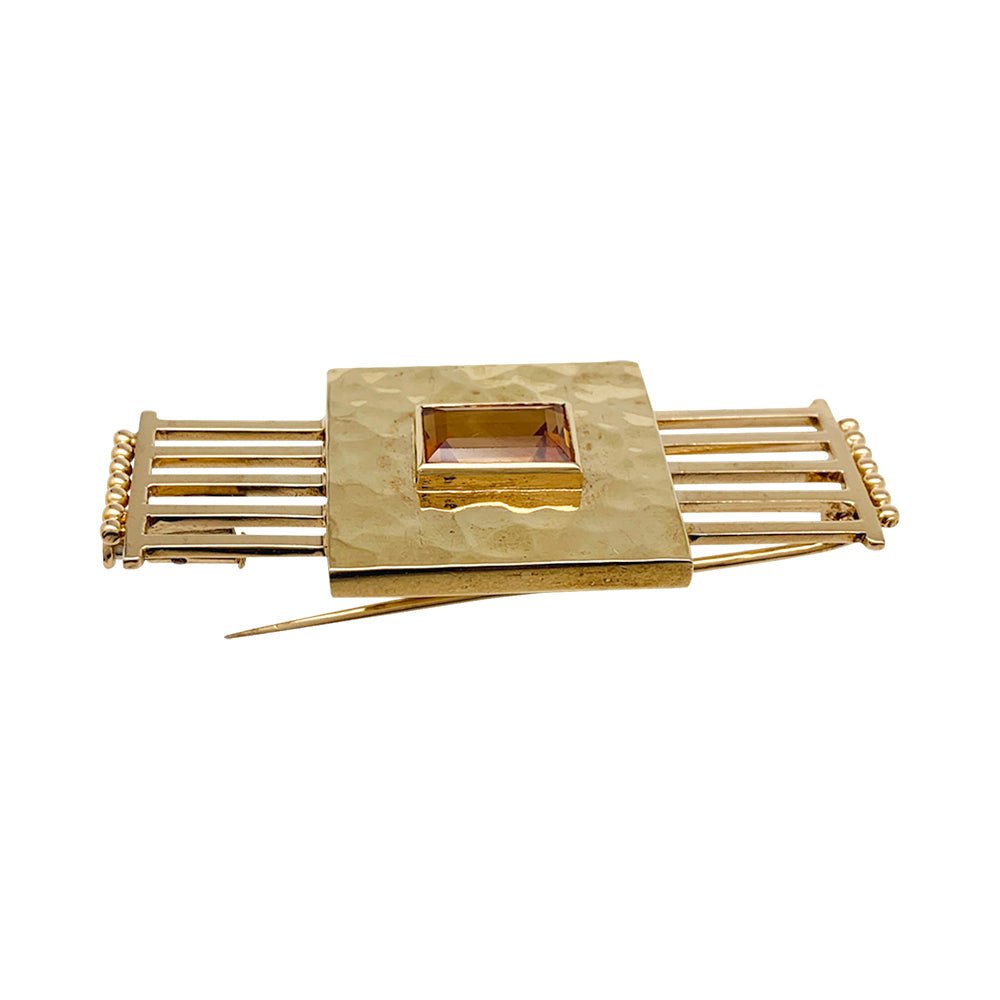 Une broche géométrique signée Jean Desprès en or jaune 750/000 martelé et lisse, centrée d’une citrine rectangulaire. Poids brut: 17,2 grammes. - Maison Eloe