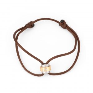 Un bracelet Cartier or et acier sur cordon de cuir